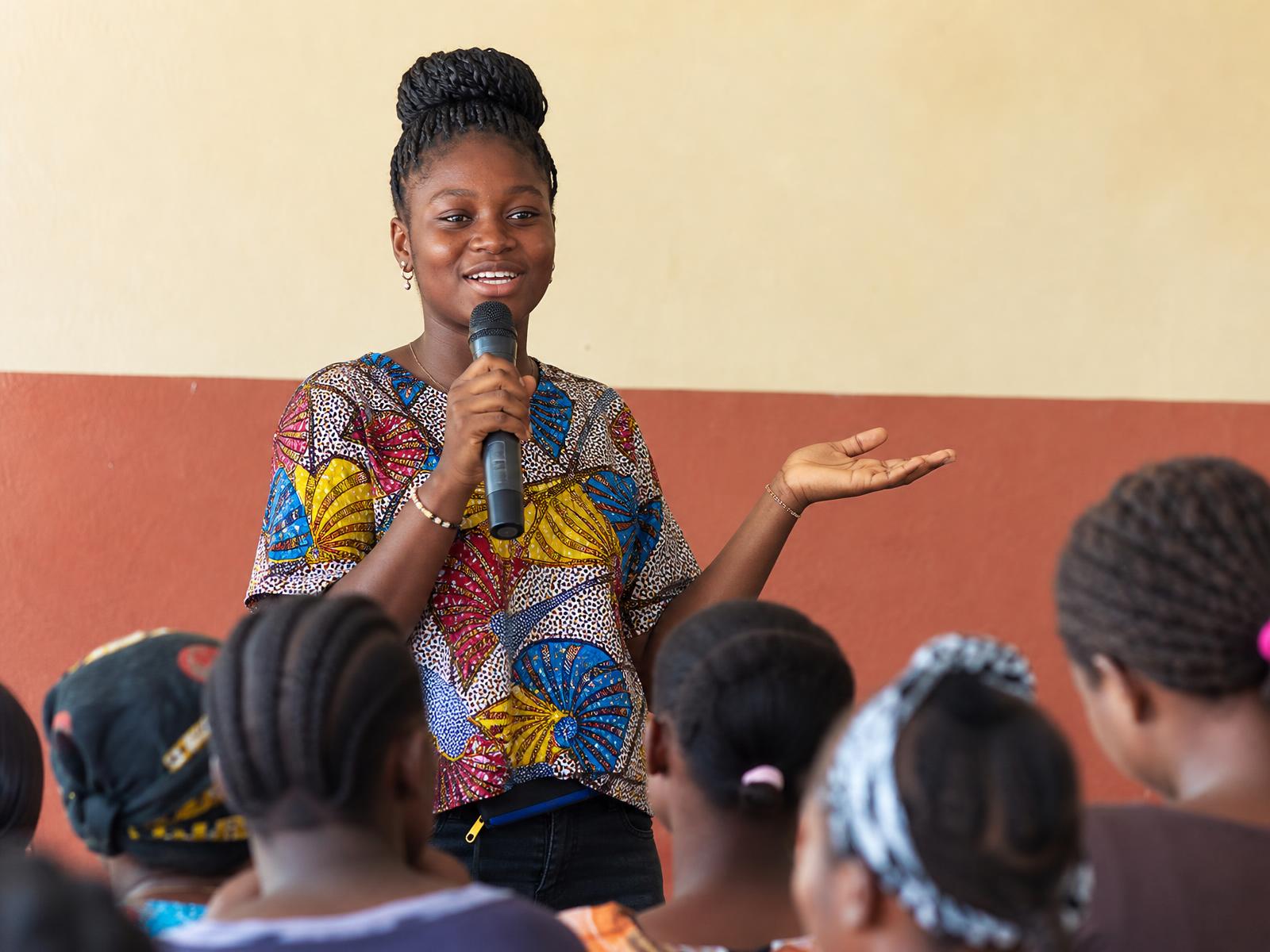 A GESL girl speaking into a microphone at a community advocacy event